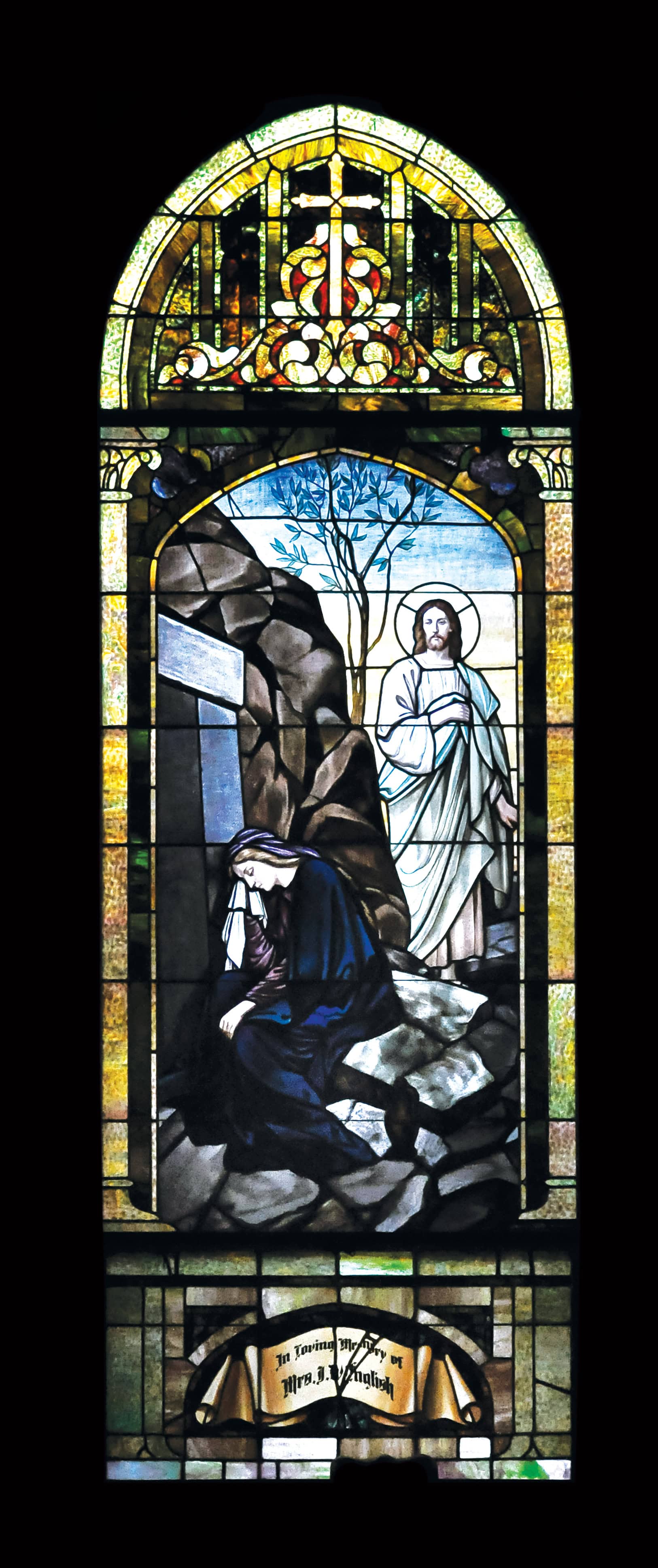 Stained glass window depicting Jesus Christ and a praying figure at Saint Andrew's Episcopal Church.