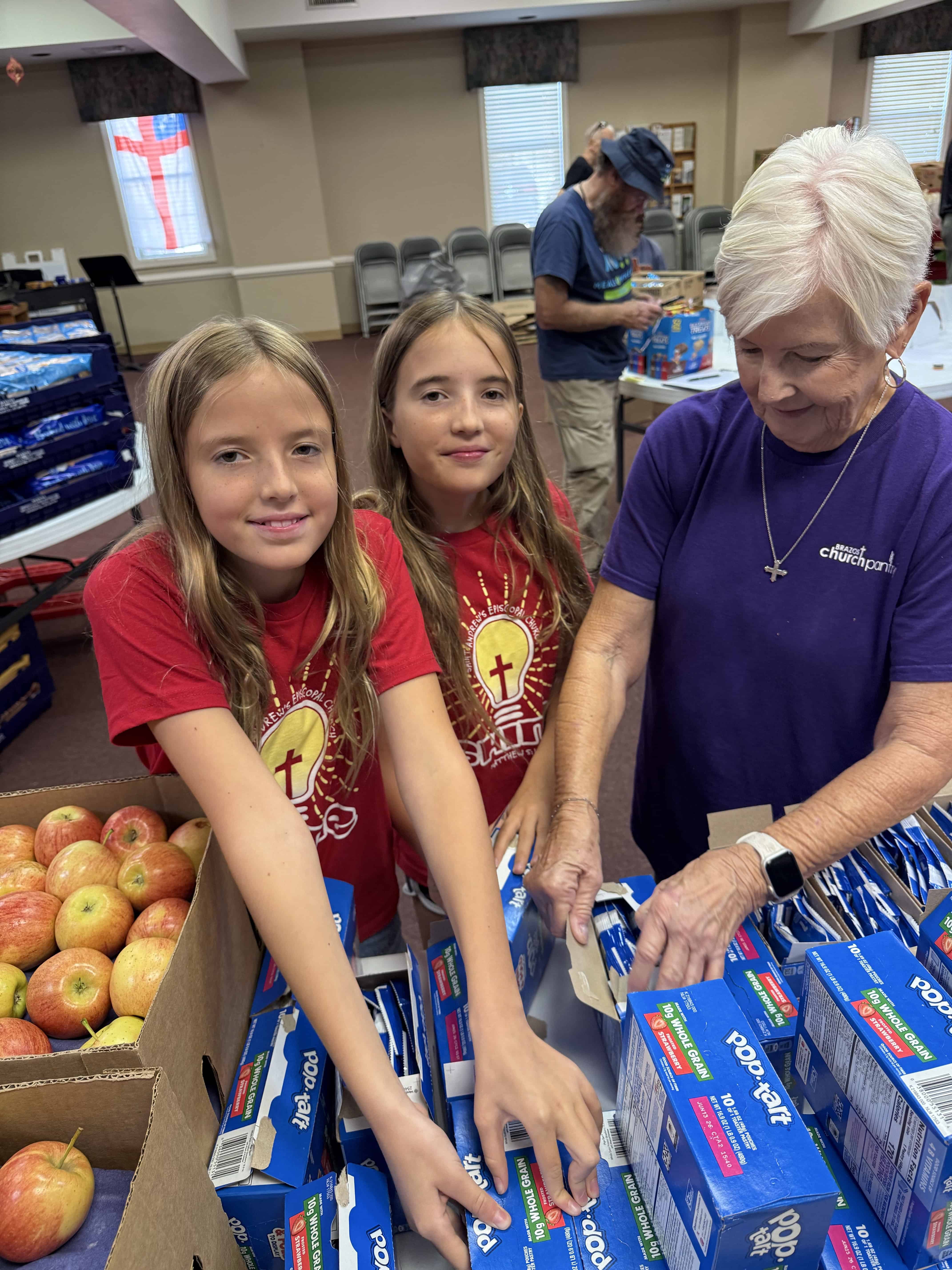 Volunteers packing food boxes at Saint Andrew's Episcopal Church food drive.